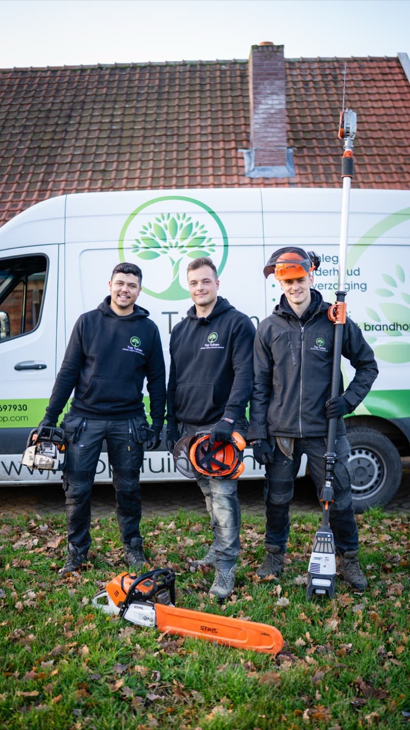 Top Tuinen team poseert met gereedschap voor de bedrijfsbus